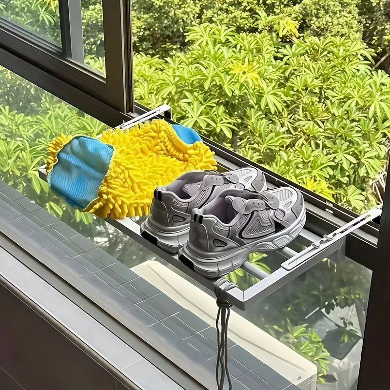 Shoe dryer on a window sill with plants in the background